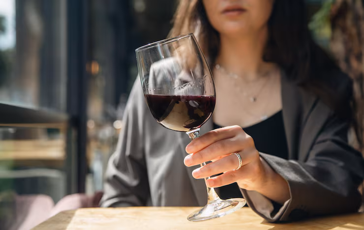 Woman drinking alcohol that may affect her skin