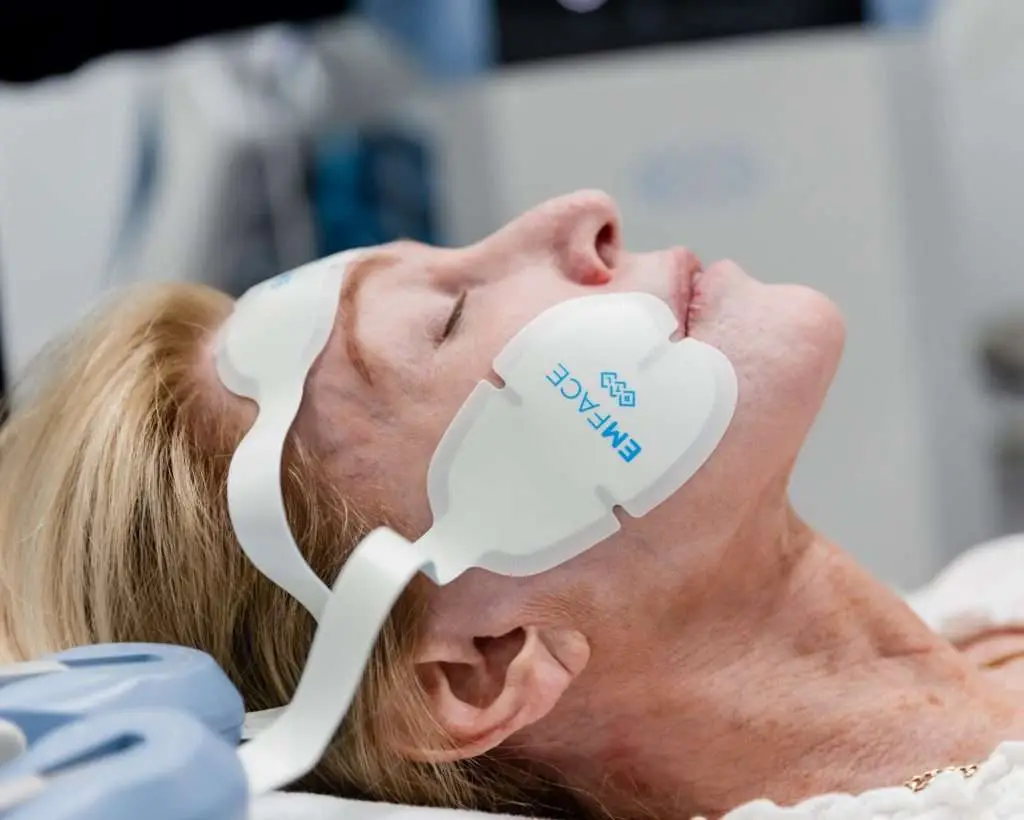 Muscle stimulating applicators positioned on the forehead and cheeks