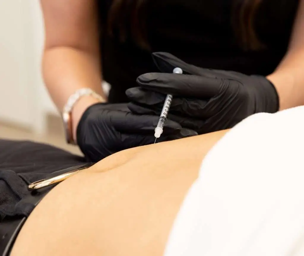 Healthcare provider administering tirzepatide, a dual-action GLP-1 and GIP medication used for medical weight loss.
