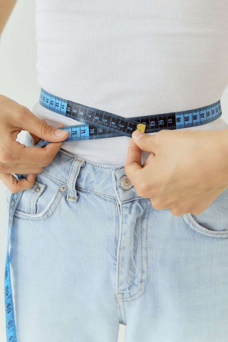Patient measuring waist circumference during a physician-supervised tirzepatide weight loss program in San Diego.