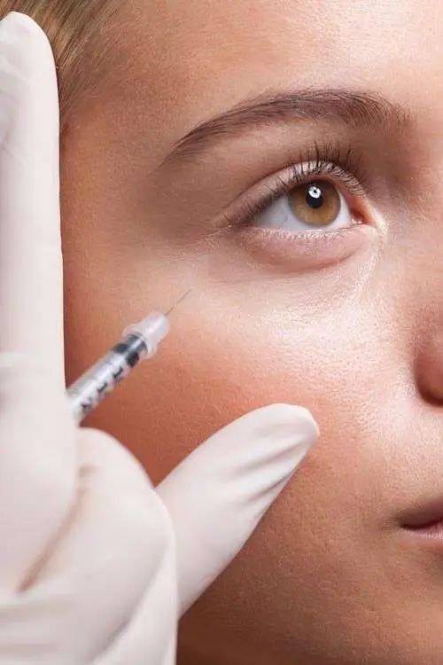 Licensed provider administering non surgical undereye injectable treatment at physician directed medical spa in San Diego