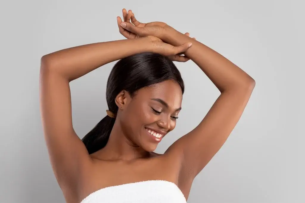 Woman with smooth dark skin smiling after completing laser hair removal at Allurant Medical in Carmel Valley San Diego