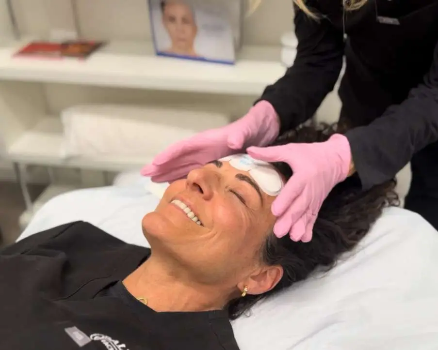 Close-up of EMFACE applicators on a patient's face during a medical spa facial treatment session in San Diego