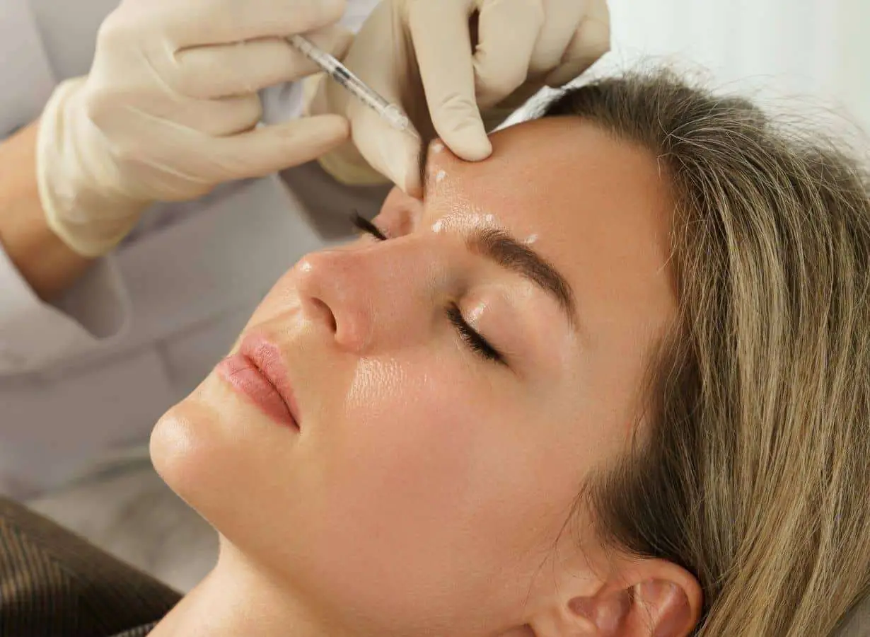 Patient reviewing dermal filler preparation tips with her provider before treatment in San Diego