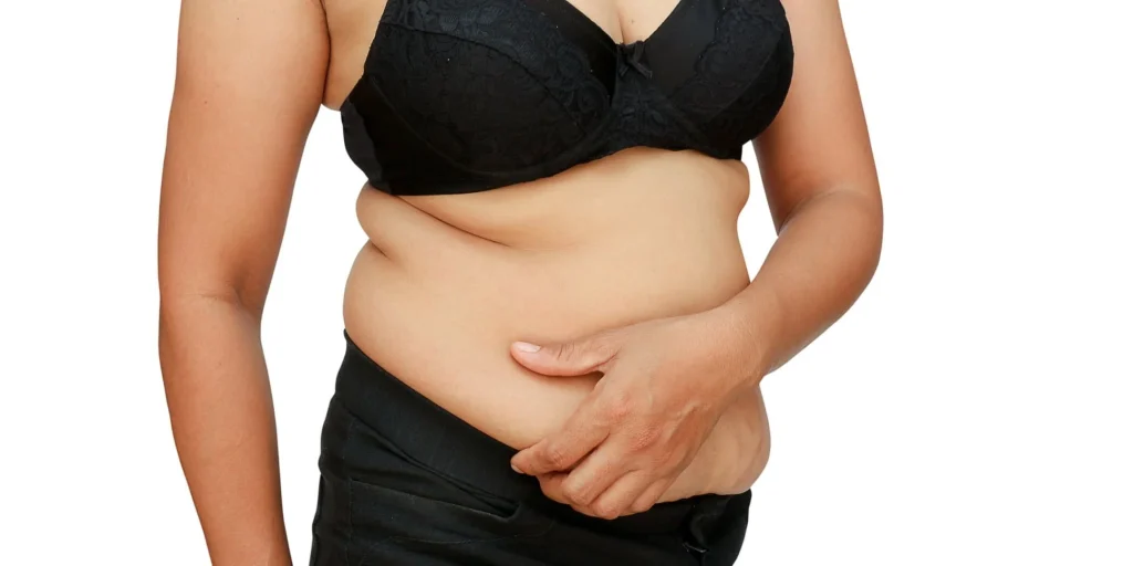 Woman comparing visceral fat vs subcutaneous fat in the abdomen